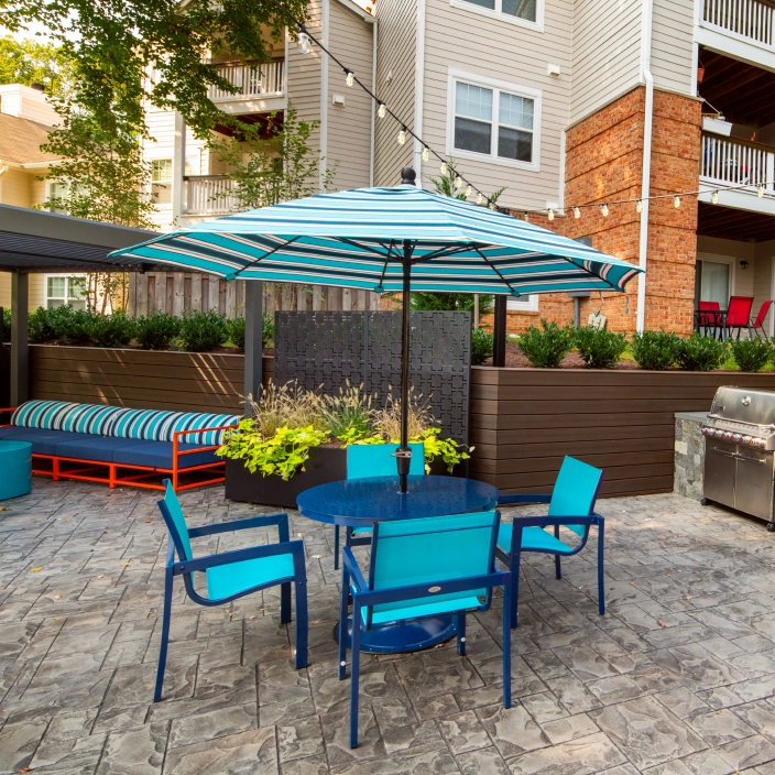 Vibrant patio area with dining tables, lounge seating, and outdoor cooking amenities included