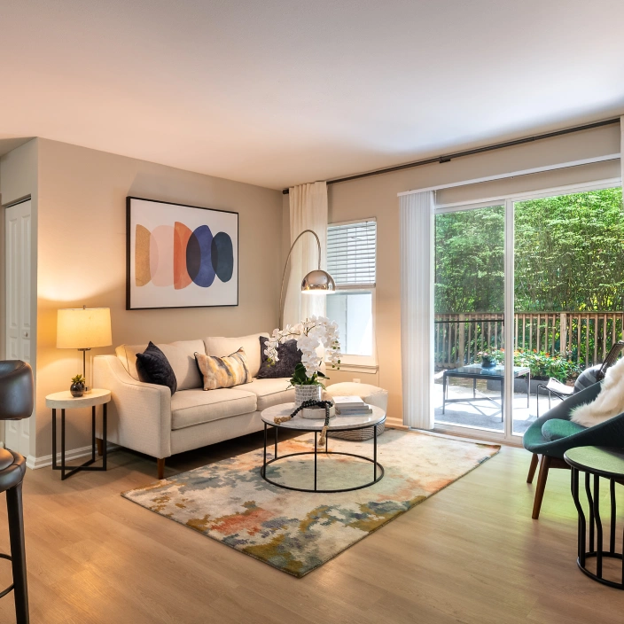 Bright apartment living space featuring neutral walls, large windows, and stylish contemporary furnishings