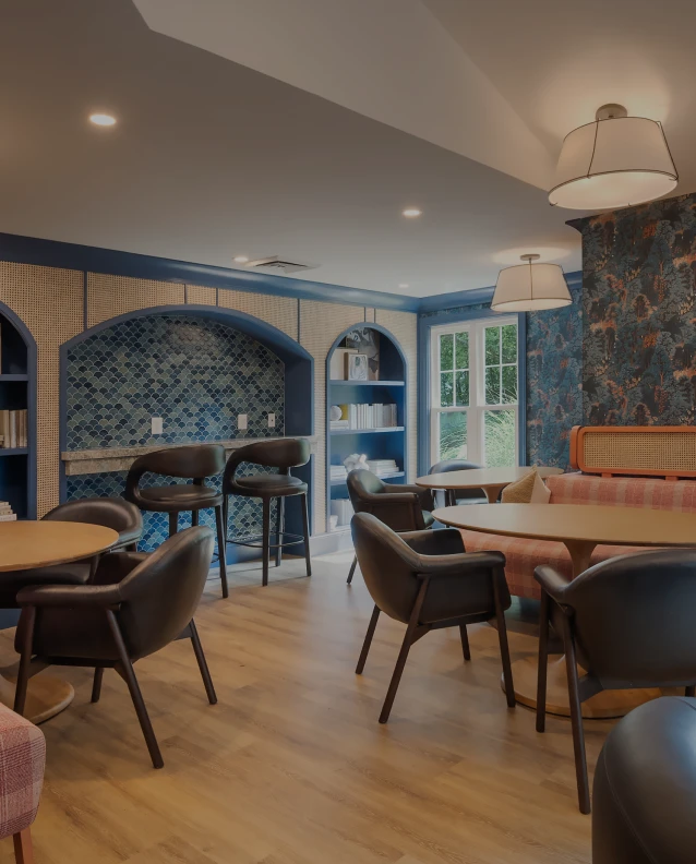 Three friends laugh around a grill on a summer afternoon