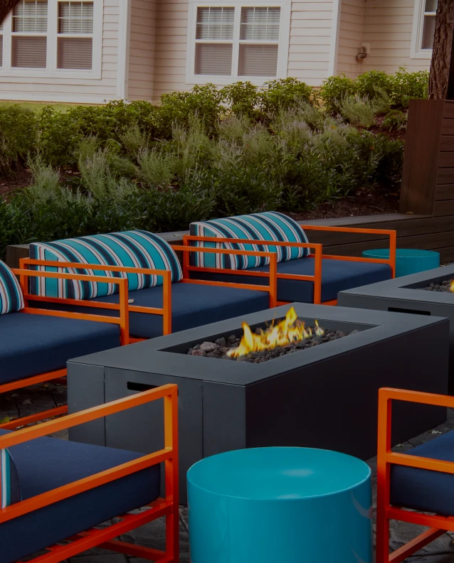 Three friends laugh around a grill on a summer afternoon