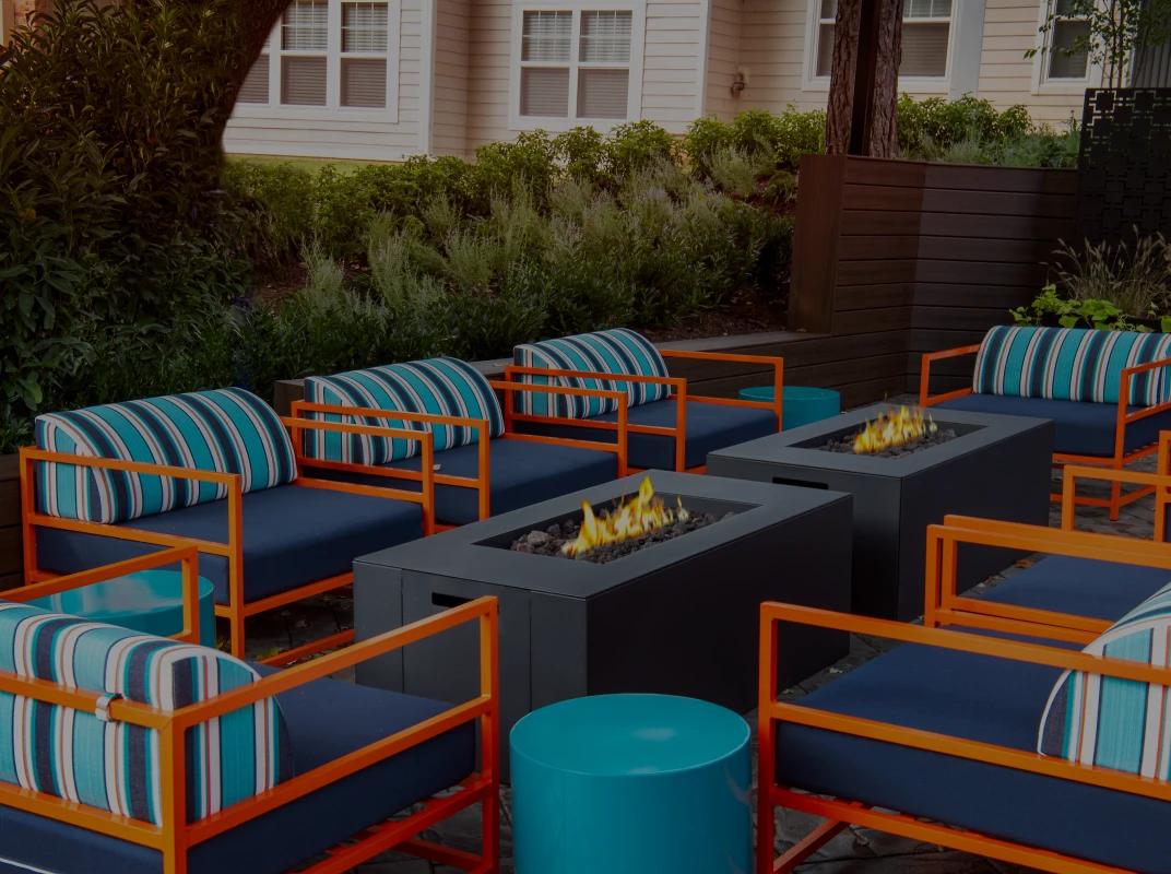 Three friends laugh around a grill on a summer afternoon