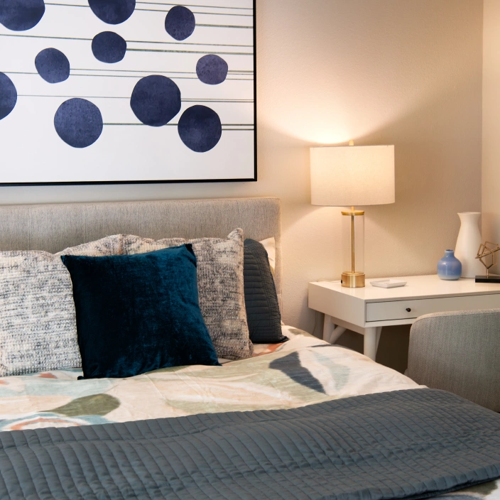 Modern bedroom with upholstered headboard, abstract wall art, and cozy accent pillows
